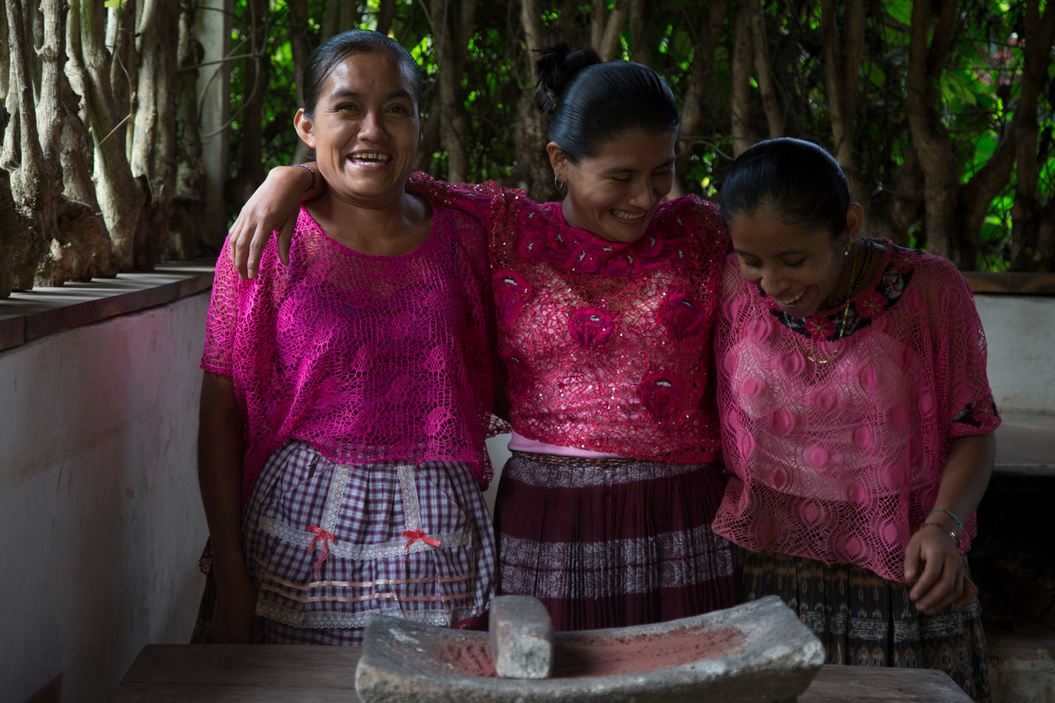 Three women from the local Maya community sharing a joyful moment
